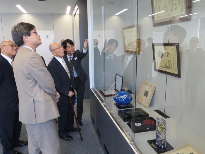 Professor Akasaki and Professor Amano look at testimonials exhibited in a showcase